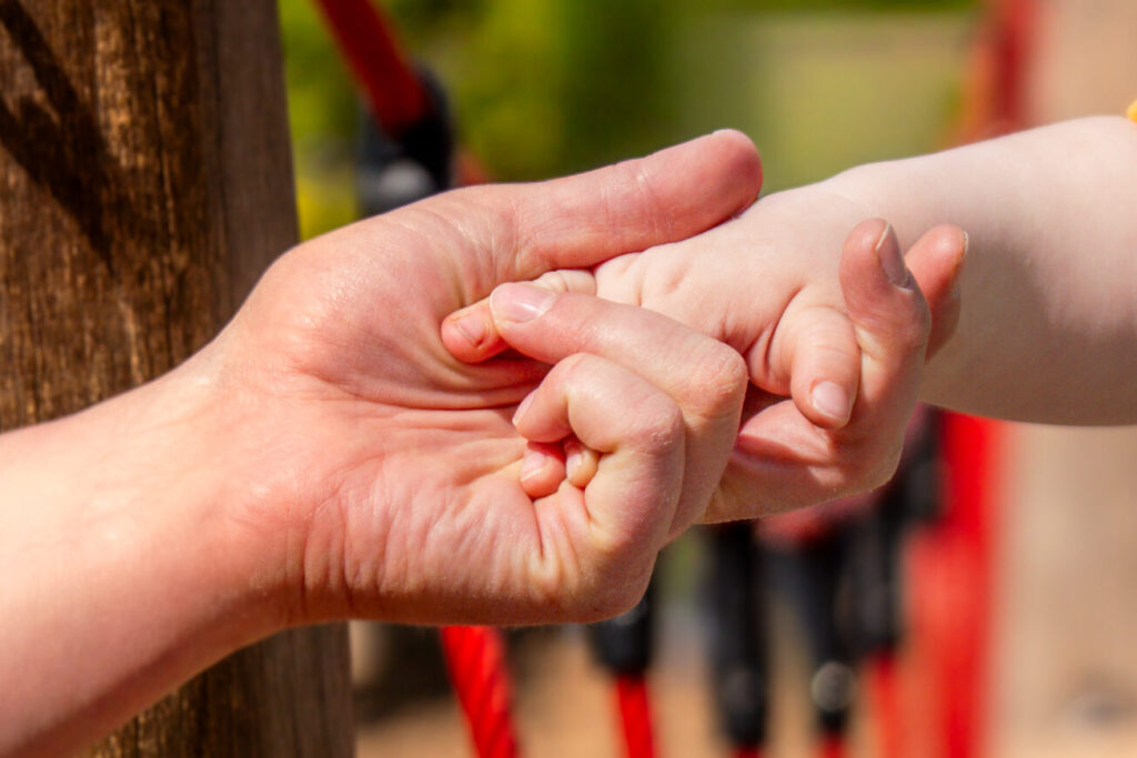Haltende Hände von Mama und Sohn