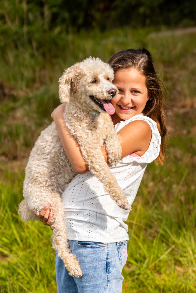 Kindershooting outdoor - Kind hält Hund auf dem Arm