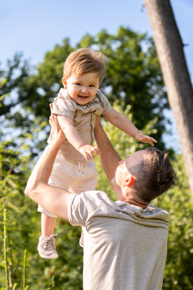 Familienshooting draußen - Papa wirft kind hoch